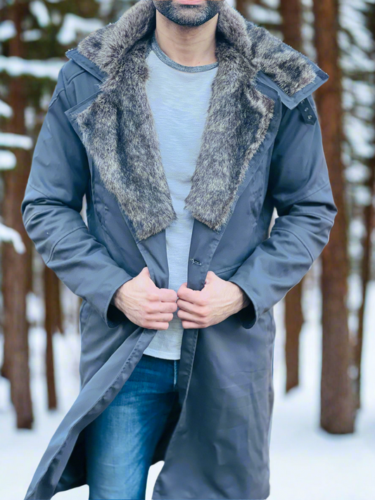 Person wearing a long coat with fur collar in a snowy forest setting
